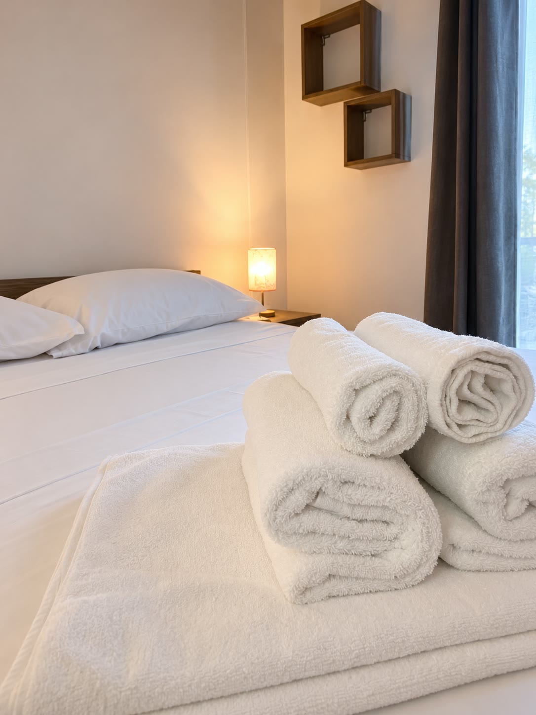 Letto matrimoniale con biancheria e asciugamani puliti